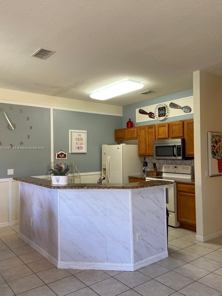 8570 Bay Lilly Loop Kissimmee, FL 34747 - Photo 8 of 36 a kitchen with granite countertop a sink and a stove top oven