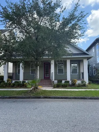 a front view of a house with a garden and trees