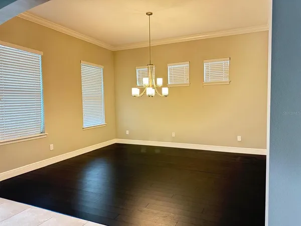 a view of a room with wooden floor and windows
