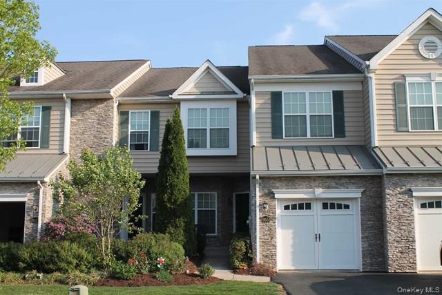 a view of a white house with large windows and a small yard