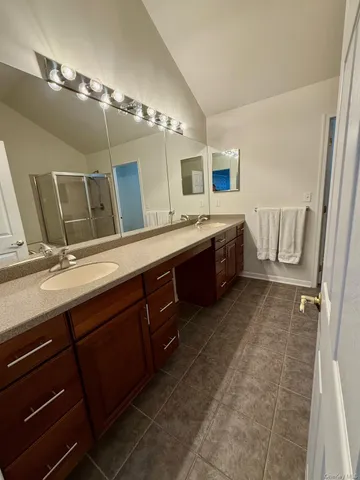 a spacious bathroom with a double vanity sink and a mirror