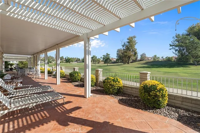 a view of a patio with a table chairs potted plants and a swimming pool