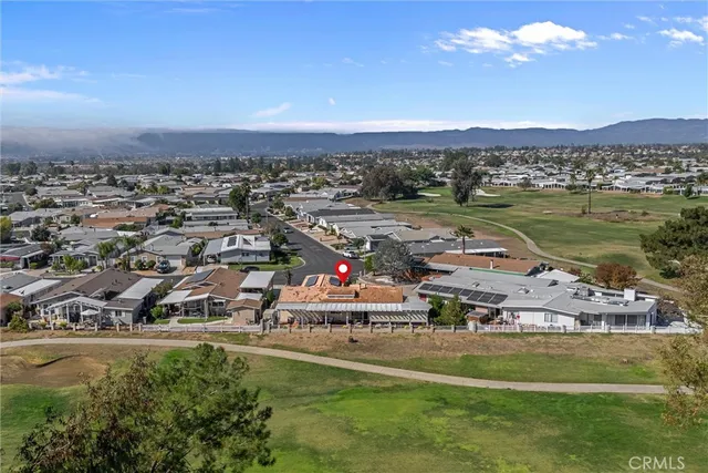 an aerial view of residential houses with outdoor space and ocean view