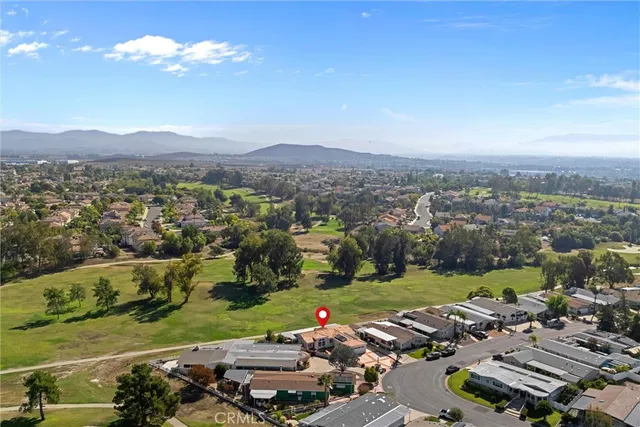 an aerial view of a city with lots of residential buildings ocean and mountain view in back