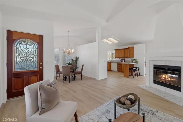a living room with furniture a fireplace and a dining table with wooden floor