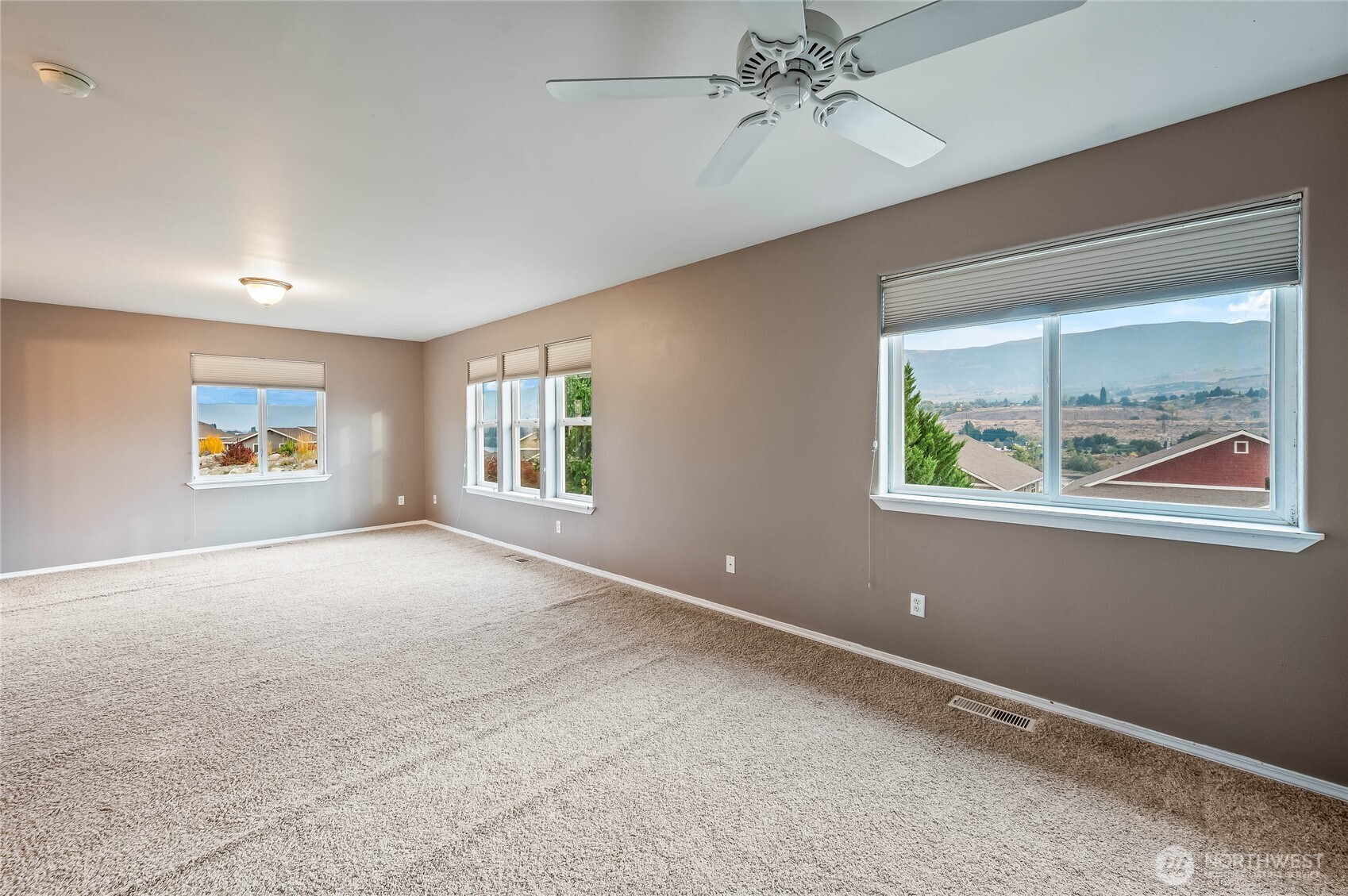 2840 Akamai Way East Wenatchee, WA 98802 - Photo 15 of 39 an empty room with windows and chandelier fan