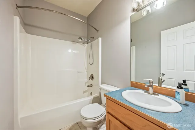 a bathroom with a granite countertop sink toilet a mirror and shower