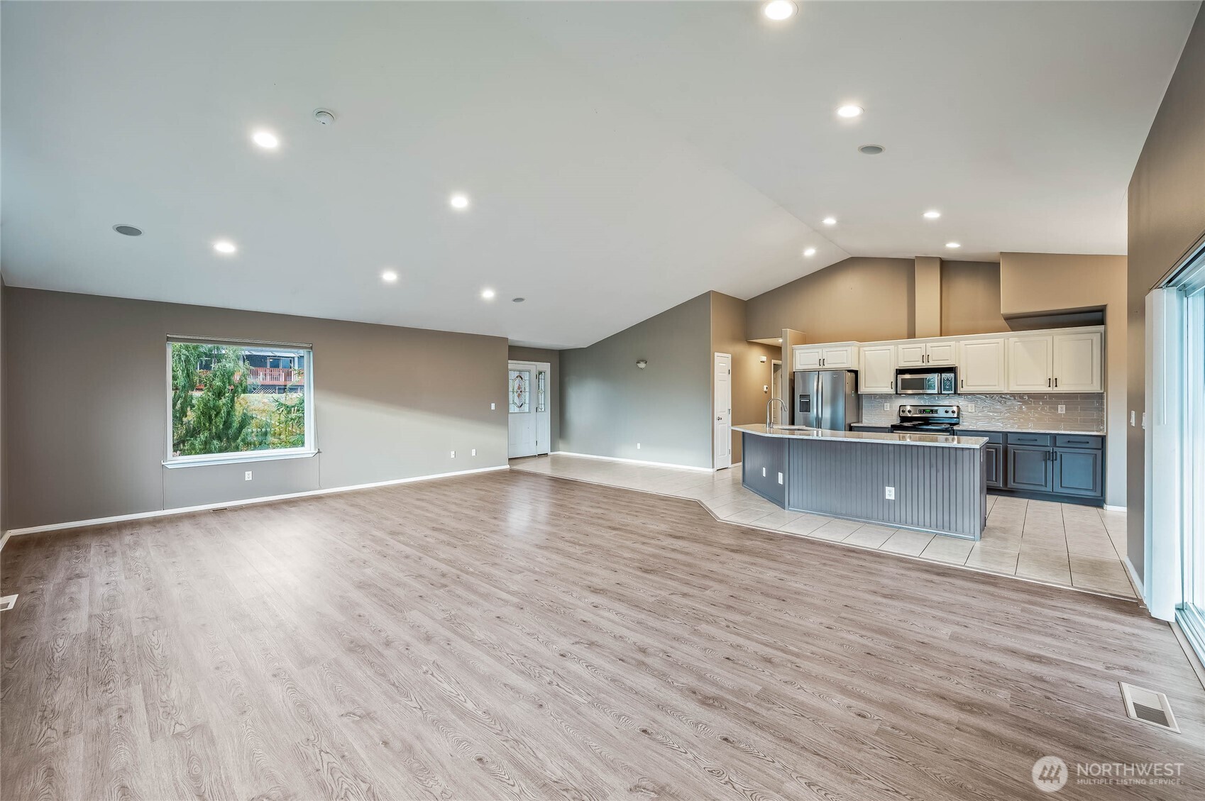 2840 Akamai Way East Wenatchee, WA 98802 - Photo 9 of 39 an open kitchen with kitchen island a sink wooden floor and a counter top space
