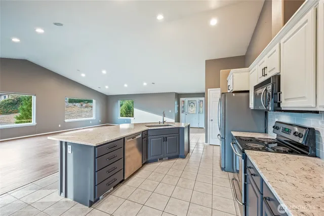 a kitchen with stainless steel appliances granite countertop a sink and a stove