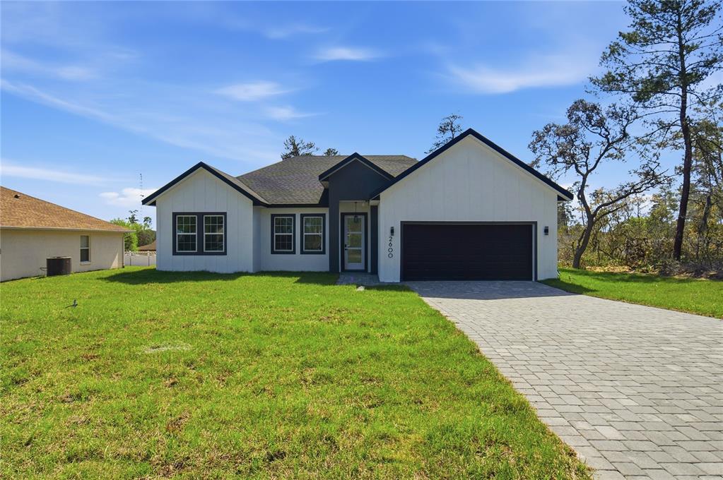 2600 Southwest 146th Pl Road Ocala, FL 34473 - Photo 1 of 40 a front view of a house with a yard and garage