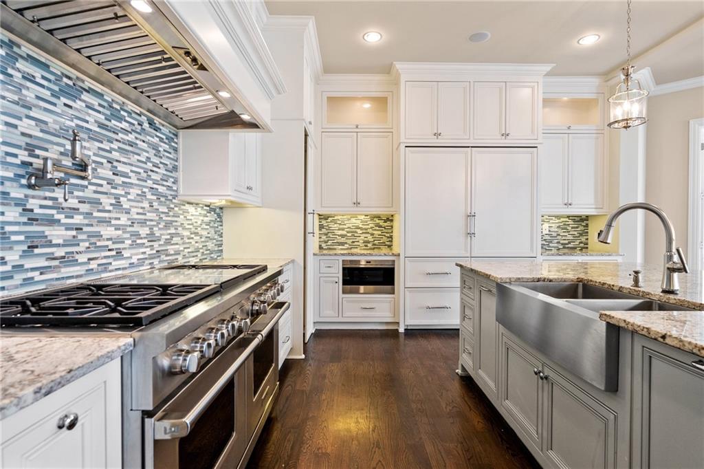 14560 Wood Road Milton, GA 30004 - Photo 19 of 74 a kitchen with stainless steel appliances a stove a sink dishwasher a refrigerator and white cabinets with wooden floor