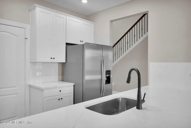 a kitchen with a refrigerator and a sink