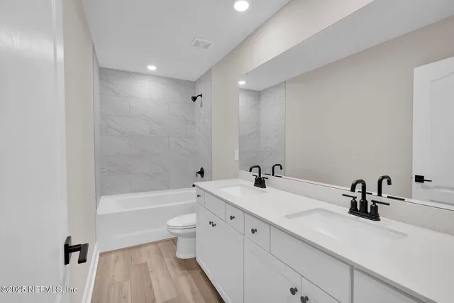 a bathroom with a sink a toilet and a large mirror