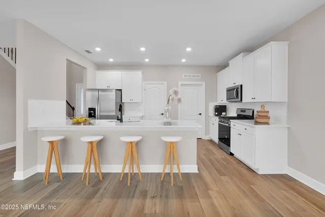 a kitchen with white cabinets and appliances