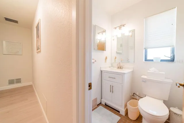 a bathroom with a sink a toilet a mirror and vanity