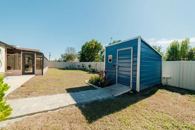 a view of backyard with potted plants and a wooden fence