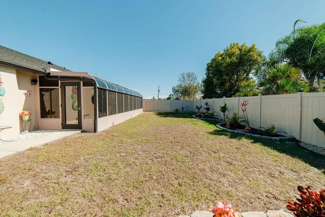 a view of a house with backyard and trees