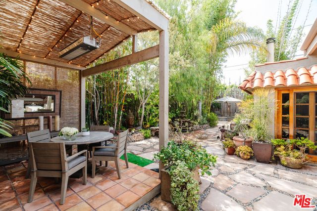 a view of a patio with a table and chairs and potted plants