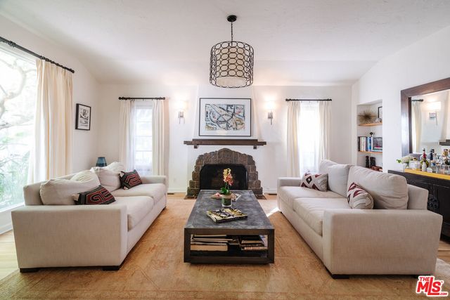 a living room with furniture a chandelier and a fireplace