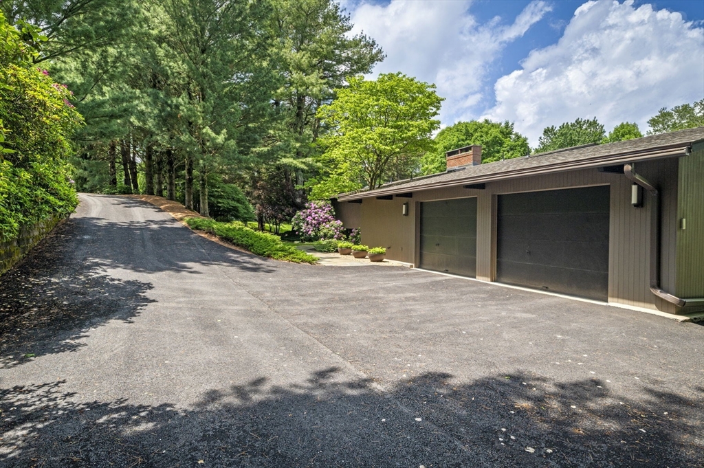 345 Cartwright Road Needham, MA 02492 - Photo 3 of 42 a front view of a house with a yard and garage