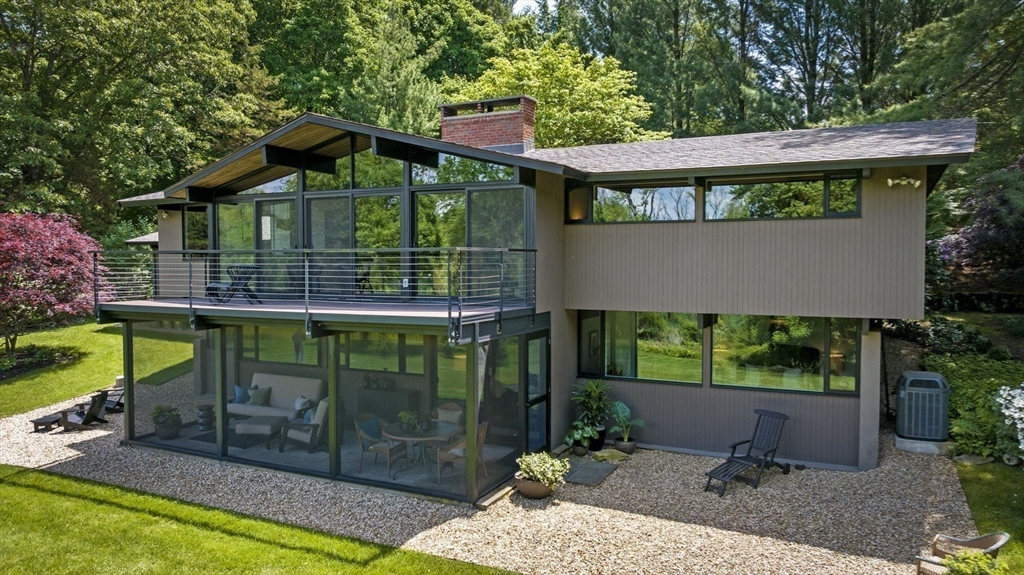 345 Cartwright Road Needham, MA 02492 - Photo 4 of 42 a view of a wooden house with a yard potted plants and large tree