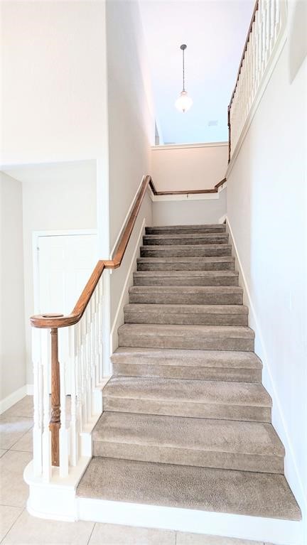 20909 Springport Court Katy, TX 77450 - Photo 21 of 39 Elegant staircase with plush carpeting and wooden handrails, leading to an upper level with soft, natural lighting.