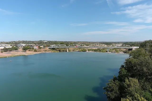 an aerial view of ocean and residential houses with outdoor space