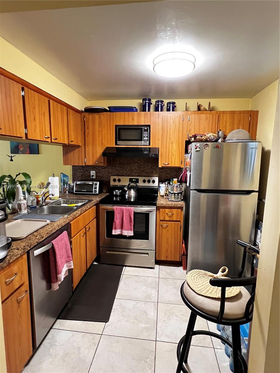 14175 Southwest 87th Street, Unit C208 Miami, FL 33183 - Photo 4 of 8 a kitchen with stainless steel appliances granite countertop a refrigerator a sink a stove a microwave and a refrigerator