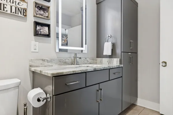 a bathroom with a granite countertop sink a toilet and a mirror