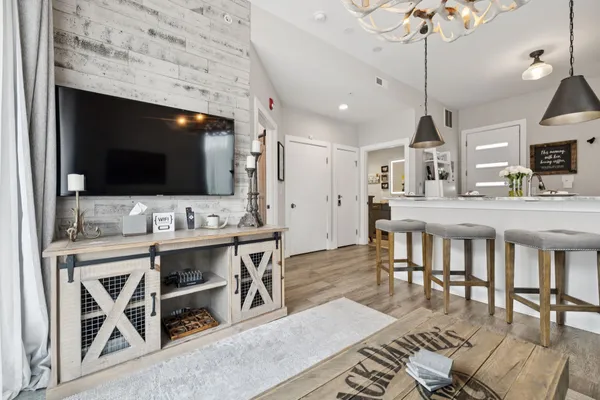 a living room with furniture a flat screen tv and kitchen view