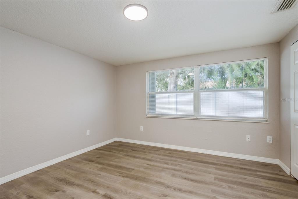 3538 Bluebell Lane Holiday, FL 34691 - Photo 17 of 25 an empty room with wooden floor and windows