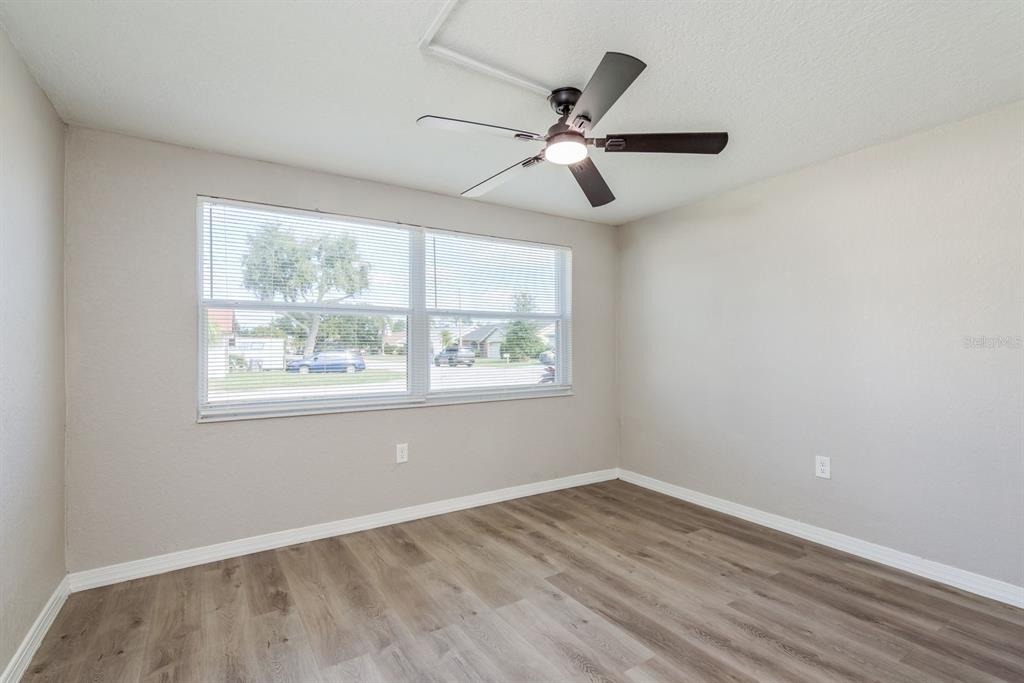 3538 Bluebell Lane Holiday, FL 34691 - Photo 19 of 25 an empty room with wooden floor windows and fan