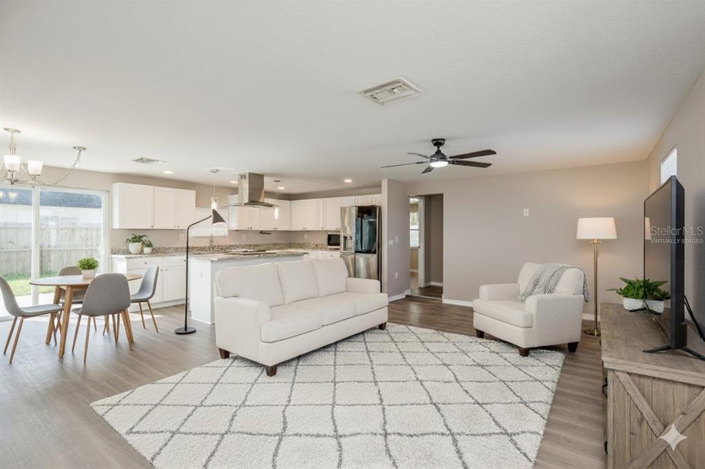 3538 Bluebell Lane Holiday, FL 34691 - Photo 3 of 25 a living room with furniture and a dining table with kitchen view