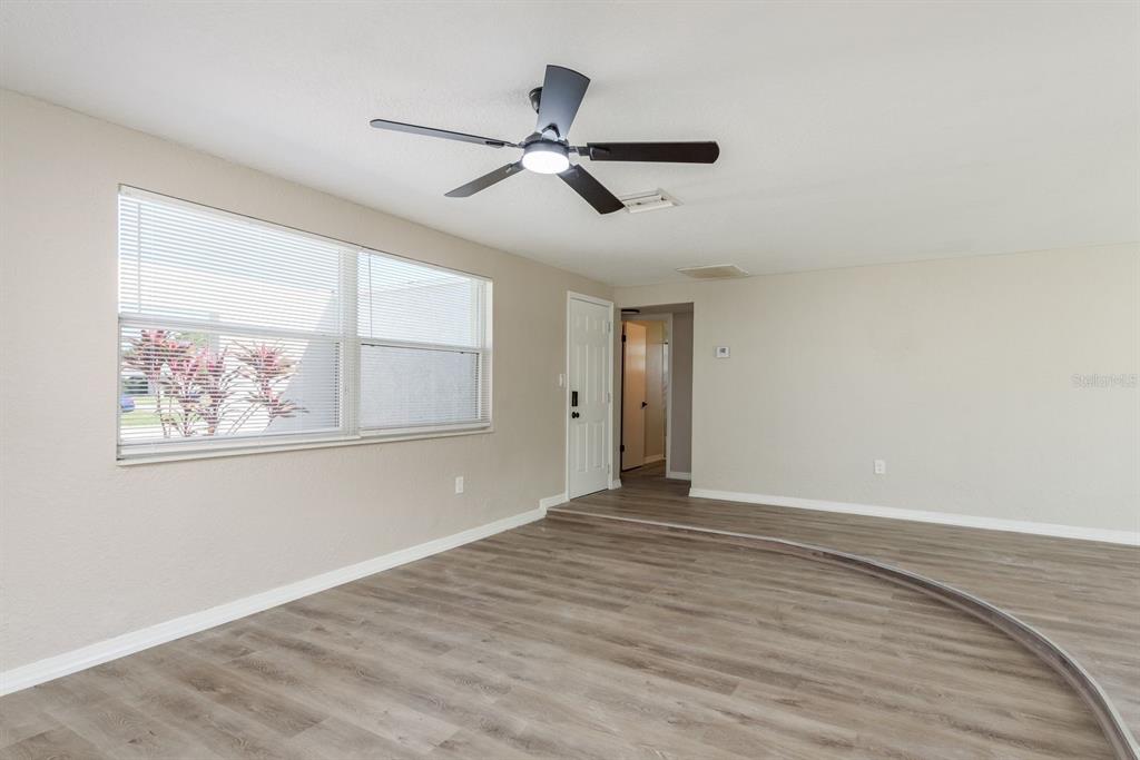 3538 Bluebell Lane Holiday, FL 34691 - Photo 4 of 25 a view of an empty room with wooden floor and a window