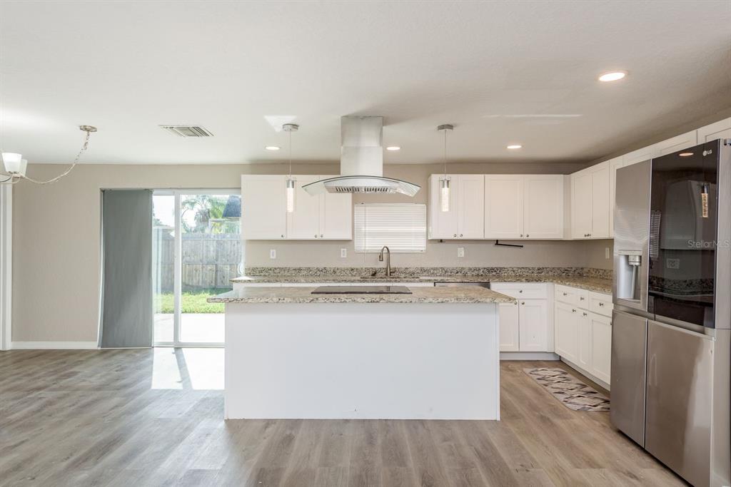 3538 Bluebell Lane Holiday, FL 34691 - Photo 8 of 25 a kitchen with stainless steel appliances granite countertop a stove a sink and a refrigerator