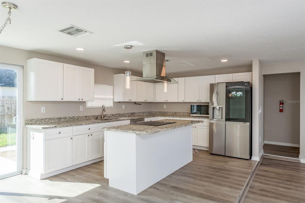 3538 Bluebell Lane Holiday, FL 34691 - Photo 9 of 25 a kitchen with stainless steel appliances granite countertop a stove and a refrigerator