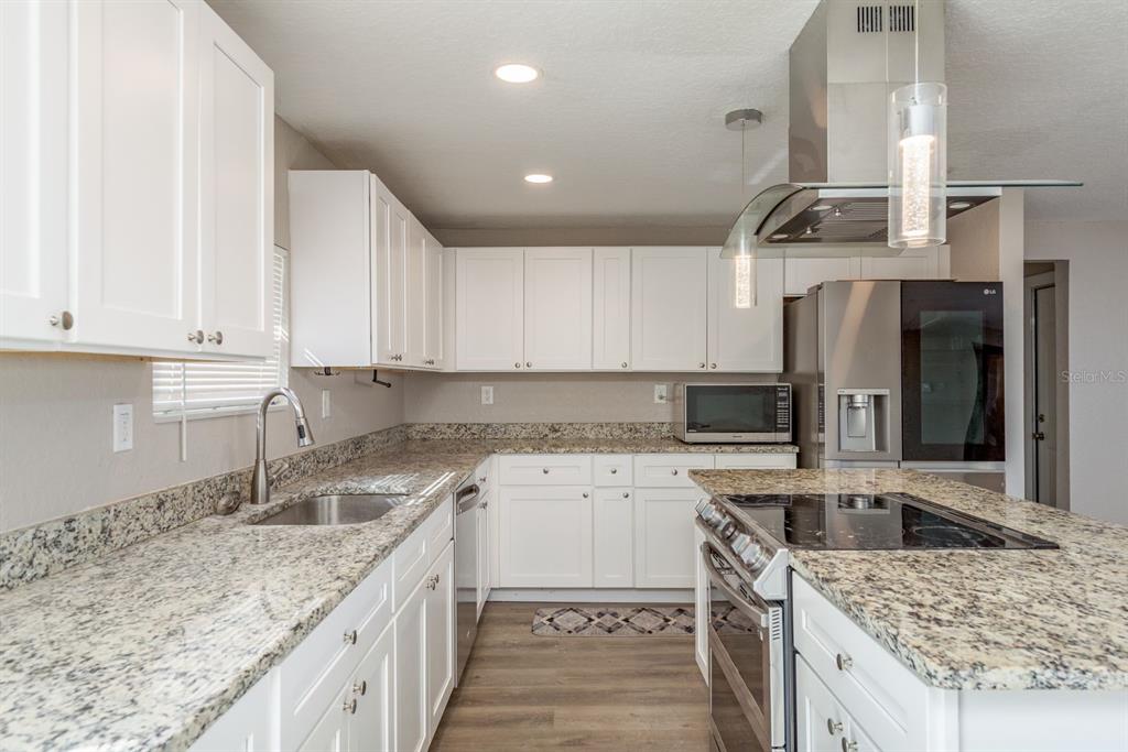 3538 Bluebell Lane Holiday, FL 34691 - Photo 10 of 25 a kitchen with a sink stove and cabinets