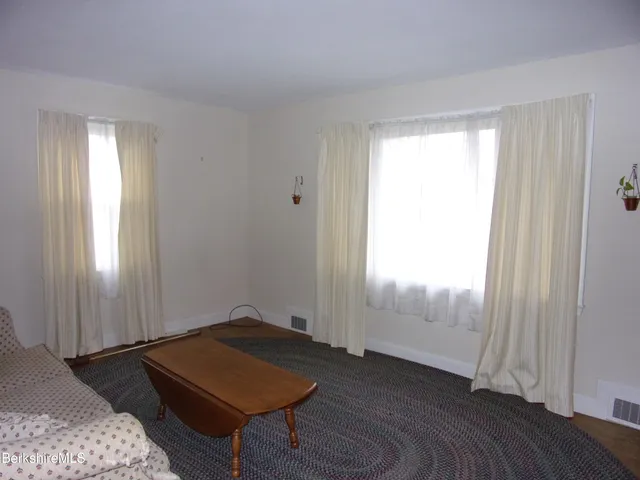 a living room with a bed and a window