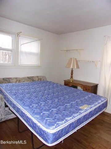 a bed sitting in a bedroom next to a window