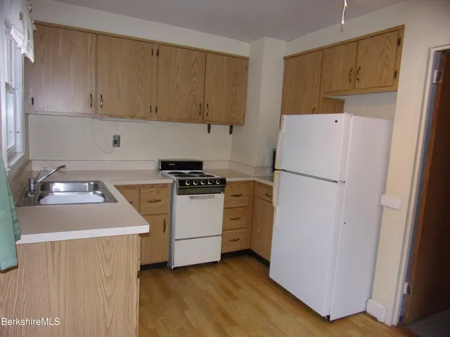 a kitchen with a refrigerator sink stove and cabinets