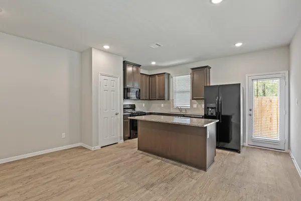 a kitchen with stainless steel appliances granite countertop a refrigerator and a stove top oven