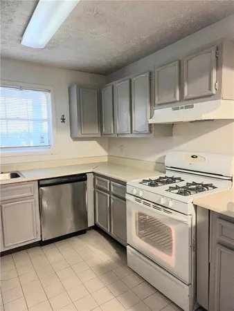 a kitchen with white cabinets and white appliances