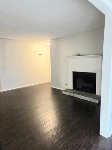 a view of empty room with wooden floor and fireplace