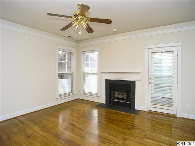 16509 Knox Run Road Huntersville, NC 28078 - Photo 5 of 16 a view of an empty room with wooden floor fireplace and a window