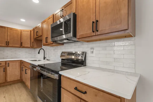 a kitchen with stainless steel appliances granite countertop a sink stove and microwave