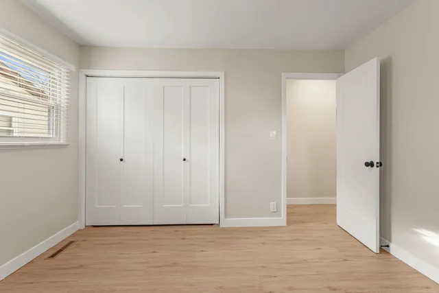 a view of an empty room with wooden floor