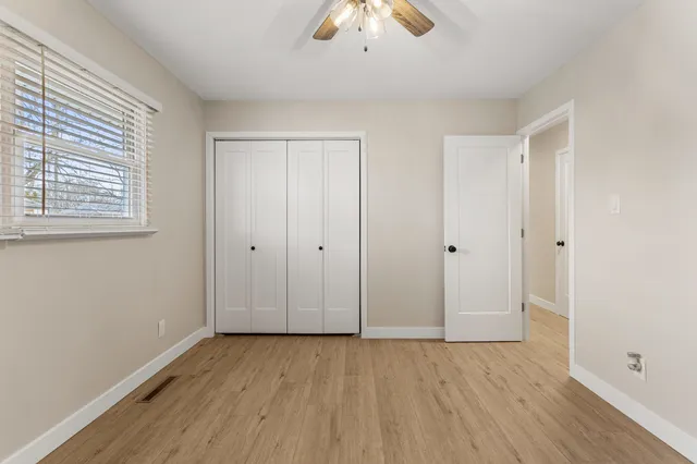 an empty room with wooden floor and windows