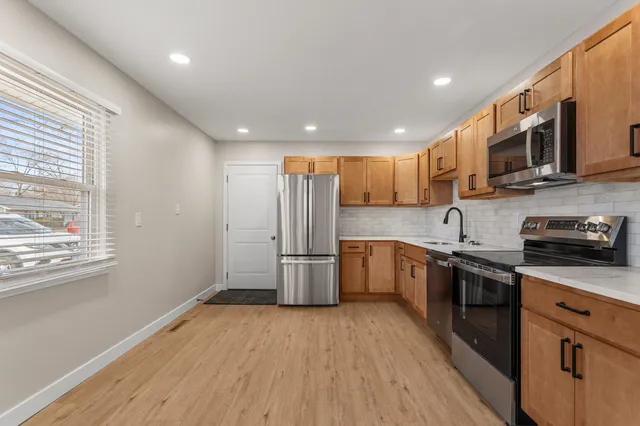 a kitchen with a sink stainless steel appliances and window