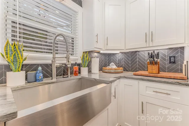 a kitchen with stainless steel appliances granite countertop a sink a stove and a window
