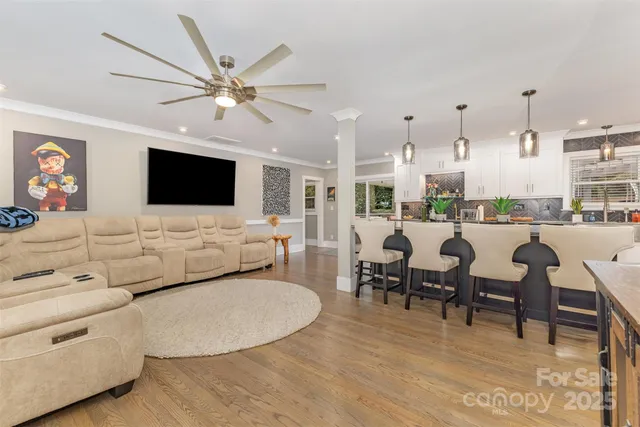 a living room with furniture kitchen view and a flat screen tv